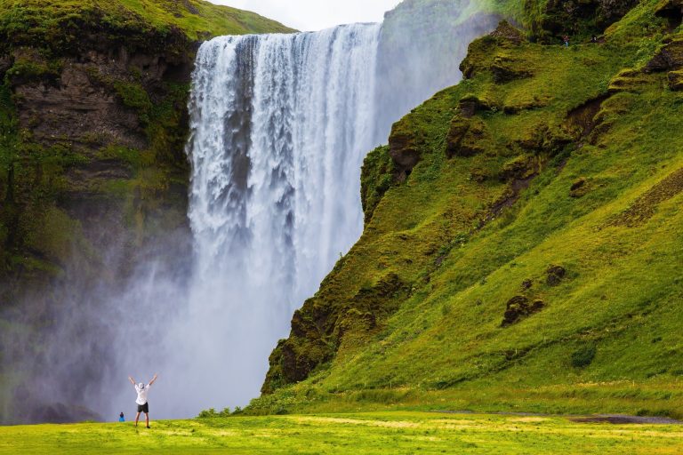 Drive in the wild nature of Iceland A large waterfall next to a mountain
